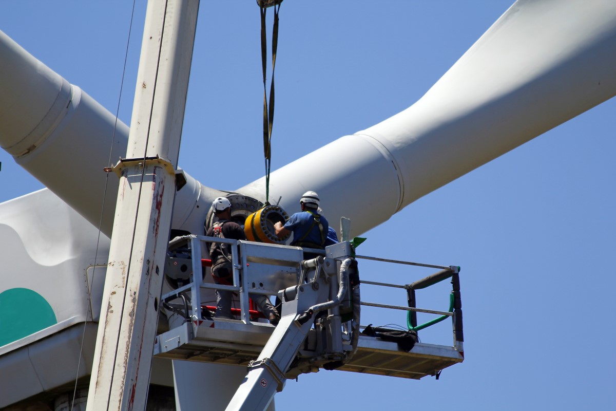 Engineers repair components in wind turbine nacelle requiring the use of precision torque wrenches.