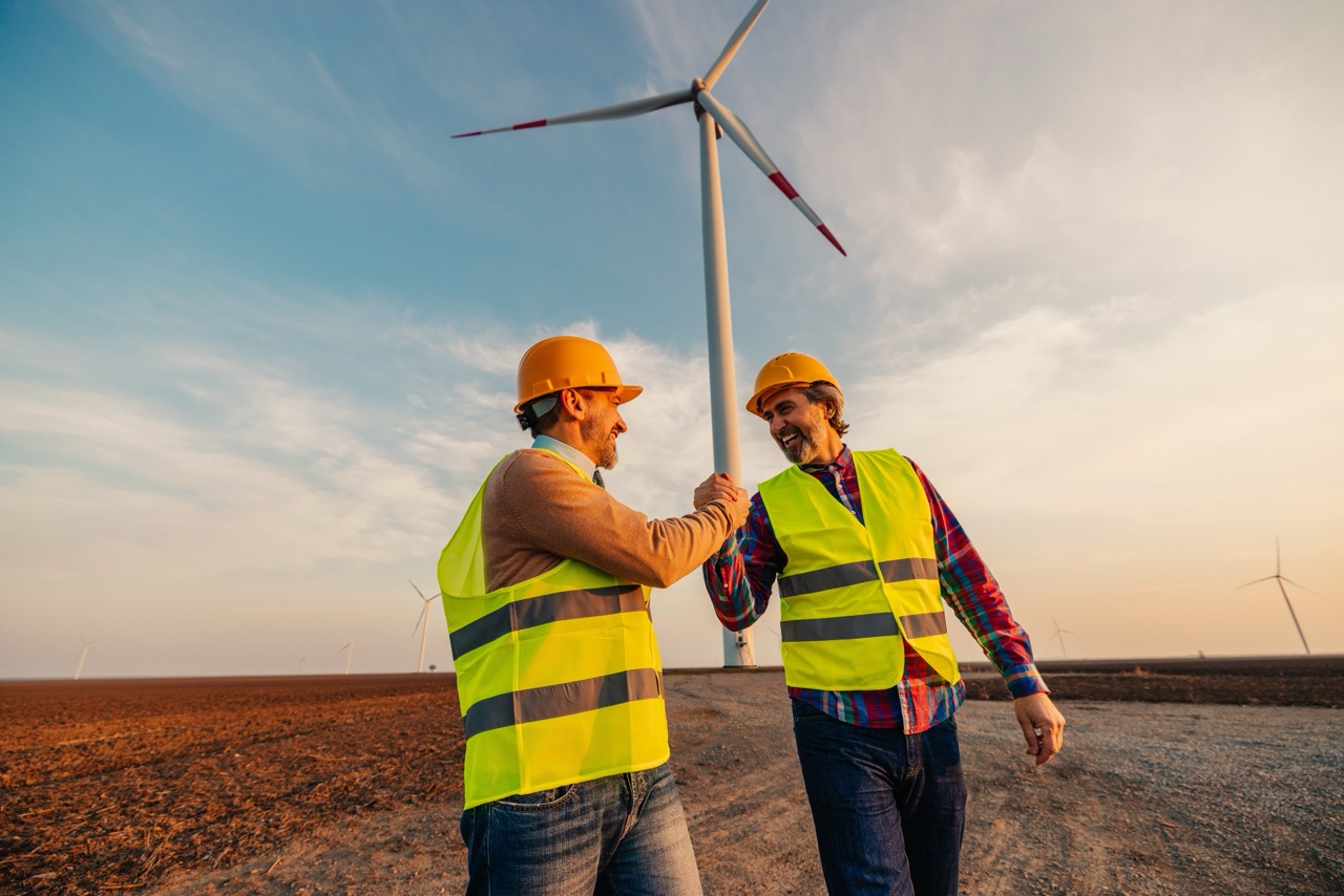 Two wind turbine technicians celebrating successful maintenance work.
